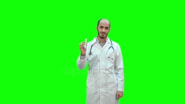 Jonge dokter voorstellende gloednieuwe geneeskunde op een groen scherm, Chromakey. — Stockvideo