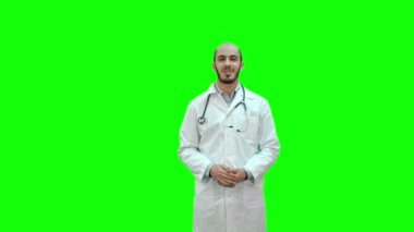 Chroma anahtar yeşil ekran kameraya konuşurken doktor gülümseyen.