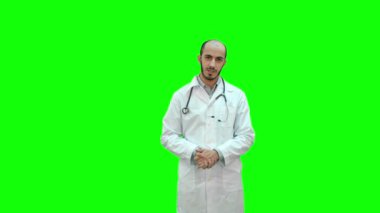 Chroma anahtar yeşil ekran kameraya konuşurken ciddi erkek doktor.