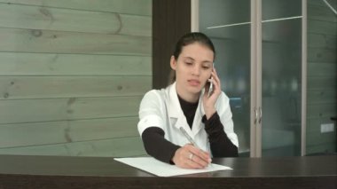 Telefonda müşteri soruları yanıtlayan Güzellik Salonu resepsiyonist