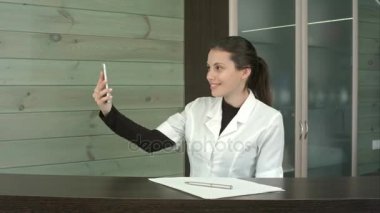 Resepsiyon masasında selfies ile telefonunu alarak mutlu spa Yöneticisi