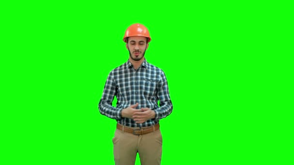 Chroma anahtar yeşil ekran kameraya konuşurken kask içinde mutlu genç mühendis. — Stok video