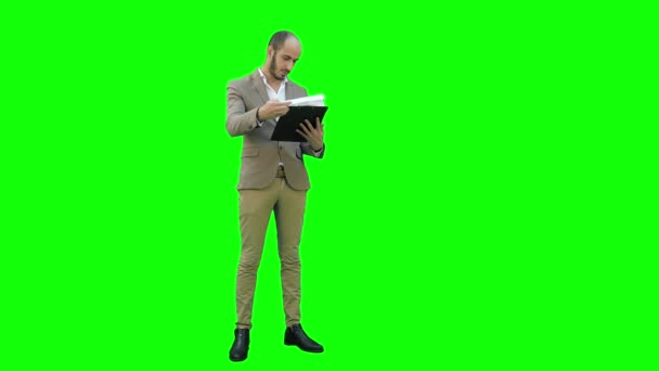 Un om de afaceri concentrat citind un raport important despre un ecran verde, Chroma Key . — Videoclip de stoc