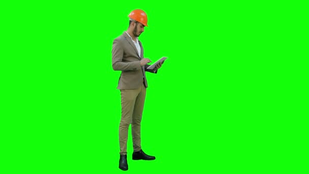 Ingeniør i hjelm som utfører inspeksjon med nettbrett på grønn skjerm, Chroma Key . – stockvideo