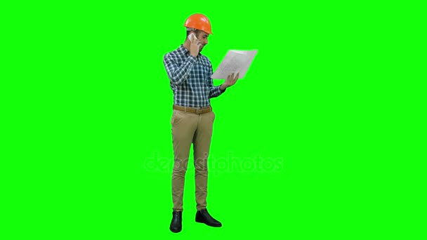 Site manager talking on mobile phone holding blueprints on a Green Screen, Chroma Key. — Stock Video