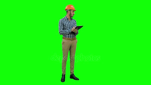 Ingenieur im Helm inspiziert Baustelle auf grünem Bildschirm, Chroma-Schlüssel. — Stockvideo