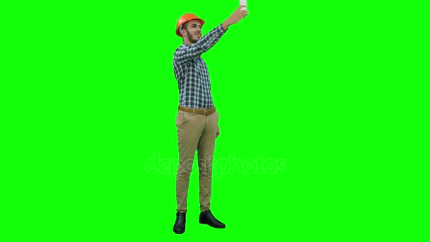 Usmívající se stavební dělník pomocí telefonu sebeportréty na zelené obrazovce, Chroma Key. — Stock video