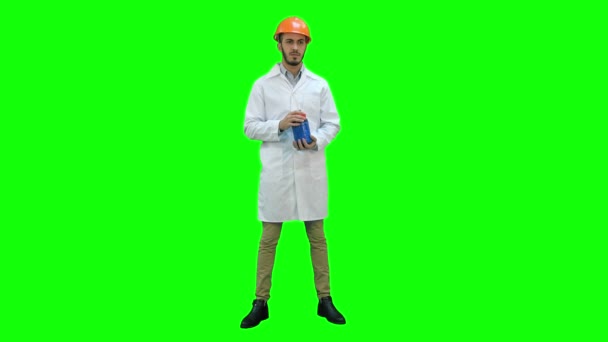Engineer in helmet and white coat starting building demolition on a Green Screen, Chroma Key. — Stock Video