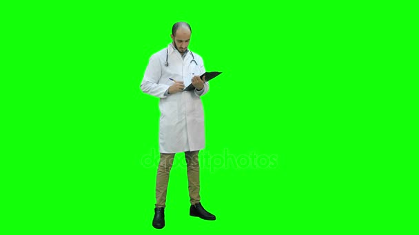 Maschio medico indossa camice bianco riempiendo in forma paziente su uno schermo verde, Chroma Key . — Video Stock