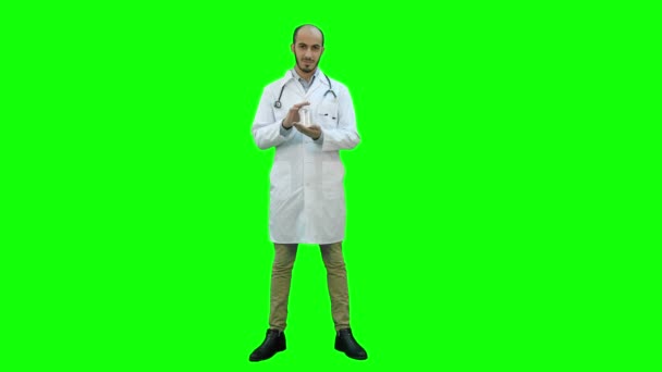 Lächelnder Arzt empfiehlt Pillen und gibt Daumen hoch auf grünem Bildschirm, Chroma-Taste. — Stockvideo
