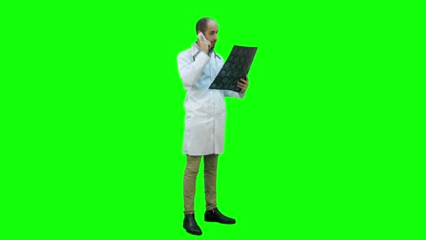 Доктор проведення Xray результатів і говорити по телефону на зелений екран, Chroma Key. — стокове відео
