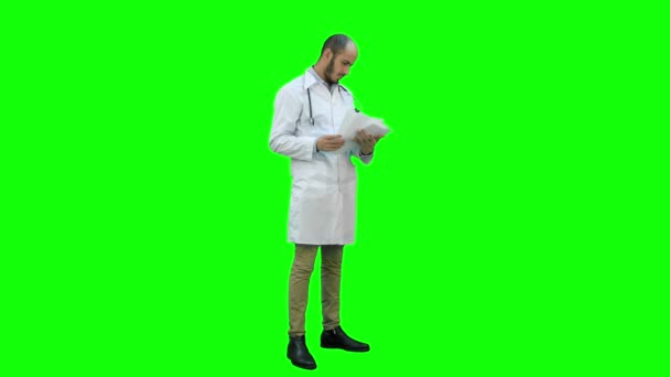 Férfi orvos orvosi dokumentumok egy zöld képernyő, Chroma-kulcs ellenőrzése. — Stock videók