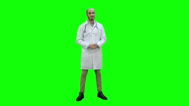 Hymyilevä mieslääkäri puhuu kameralle vihreällä näytöllä, Chroma Key . — kuvapankkivideo