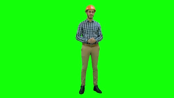 Feliz joven ingeniero con casco hablando con la cámara en una pantalla verde, Chroma Key . — Vídeo de stock