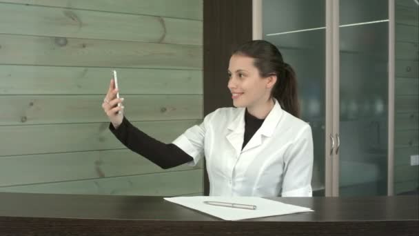 Gerente de spa feliz tomando selfies con su teléfono en la recepción — Vídeos de Stock