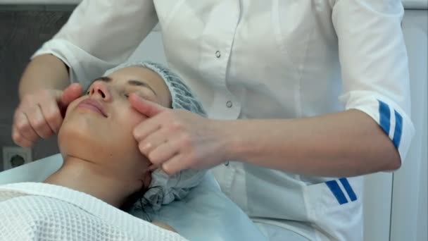 Молодая массажистка делает привлекательный женский массаж шеи и плеч в салоне красоты — стоковое видео