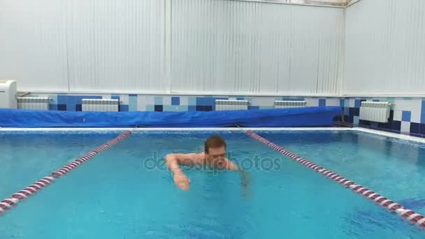 Ung man simmar det främre crawl i en pool — Stockvideo