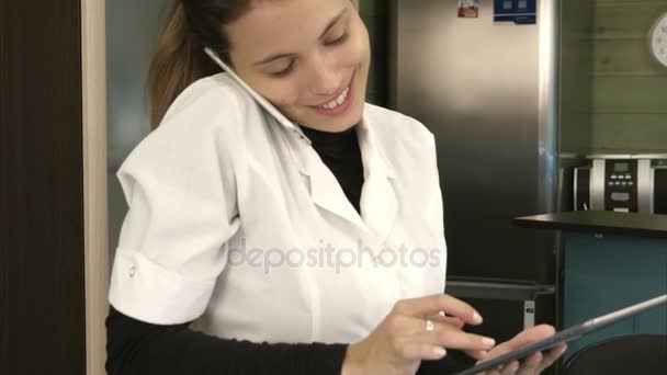 Smiling spa manager pratar i telefonen medan du använder Tablet PC i receptionen — Stockvideo