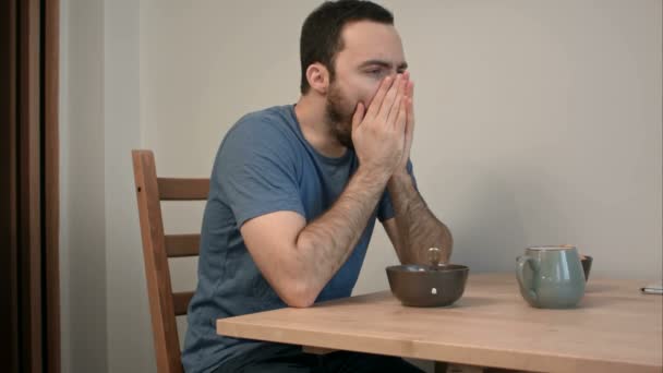 Sleepy man geeuwen aan ontbijttafel — Stockvideo