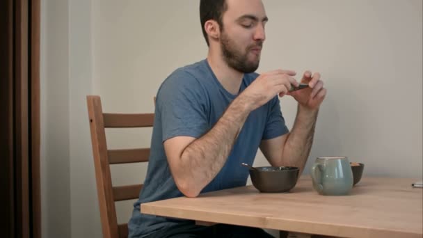 Young man being noticed taking photo of his breakfast on phone — Stock Video