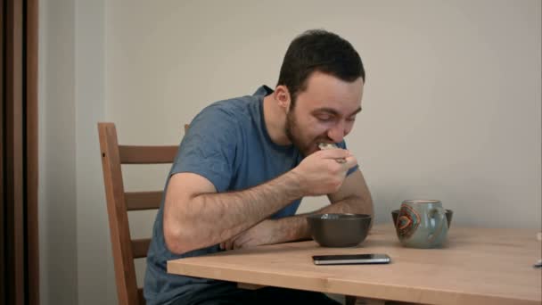 Jeune homme ayant un appel urgent au milieu du petit déjeuner — Video