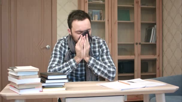 Triste et malade étudiant descendre avec la grippe assis au bureau avec des livres — Video