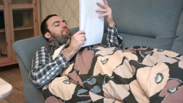 Young man with flu trying to study in bed — Stock Video