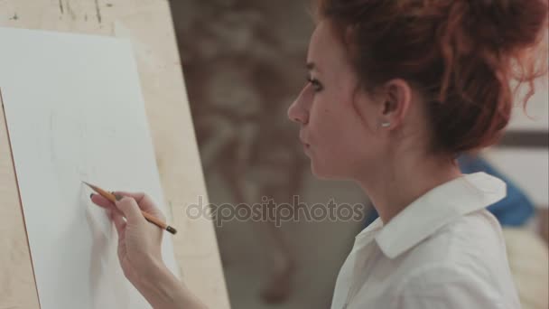 Joven pintora haciendo bocetos sobre lienzo en blanco en taller de artista — Vídeos de Stock