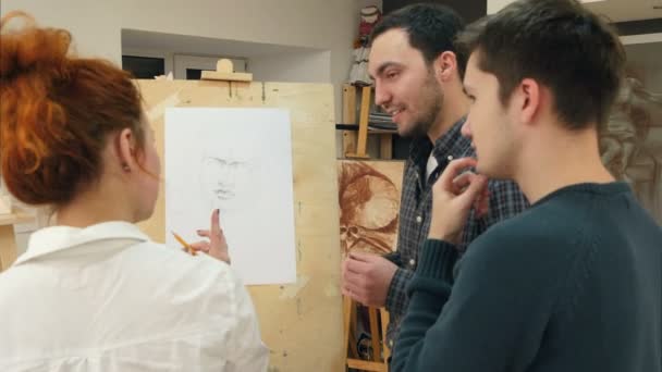 Жінка-художник навчає молодих чоловіків малювати класичний портрет — стокове відео