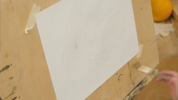 Peintre femelle arrosage papier blanc sur chevalet — Video