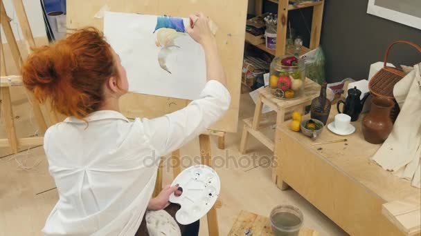 Artista femenina de jengibre usando acuarela para pintar bodegones — Vídeo de stock