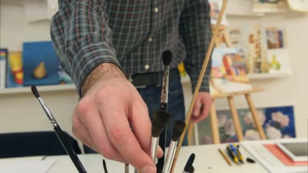 Pintor masculino escolhendo diferentes escovas para o trabalho — Vídeo de Stock