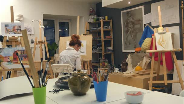 Artista femenina de jengibre pintando bodegones en estudio — Vídeos de Stock