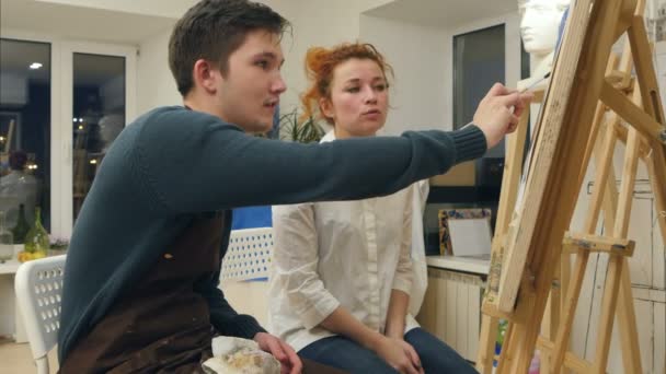 Artista femenina enseñando a la joven estudiante a pintar con acuarela — Vídeo de stock