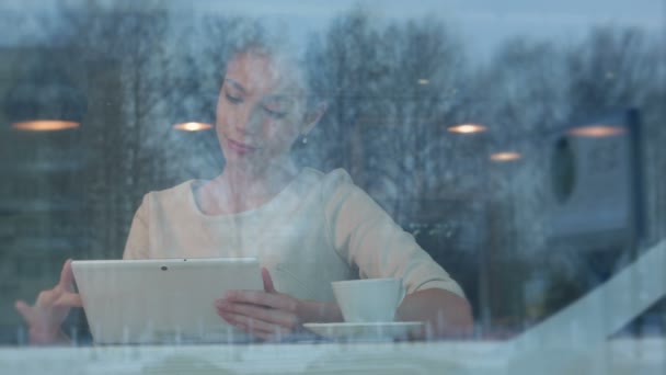Mujer joven feliz usando tableta digital en una cafetería — Vídeos de Stock