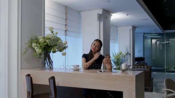 Mooie jonge meisje met behulp van telefoon check-haar make up te nemen van selfies in café — Stockvideo