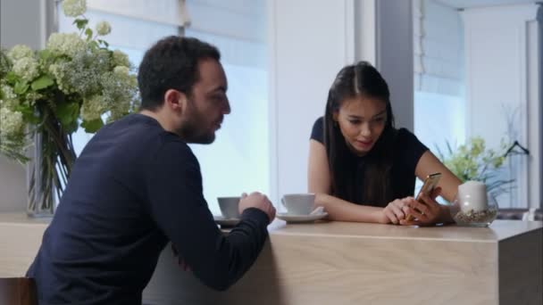 Izgatott nő és férfi néz valamit a telefon kávézó — Stock videók