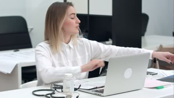 Medicul de sex feminin care examinează imaginea cu raze X stând în birou — Videoclip de stoc