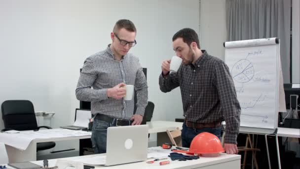 Dois colegas de trabalho do sexo masculino fazendo coffee break e conversando no escritório — Vídeo de Stock