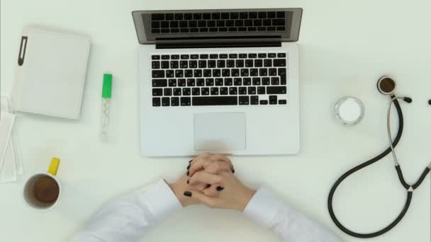 Female doctor hands typing on a laptop with stethoscope at the desk — Stock Video