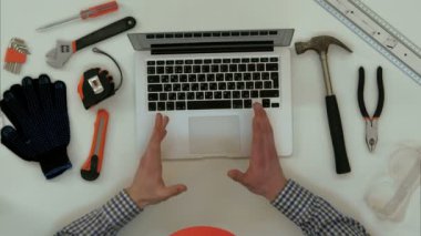 Görüntülü arama sırasında teknik resim üstünde laptop açıklayan mühendisi