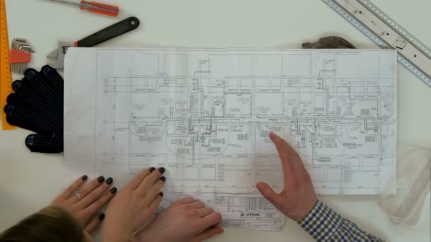 Architect bezig blueprints wanneer vrouwelijke collega brengen meer tekeningen — Stockvideo