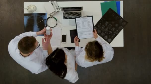 Equipe médica discutindo o que comprimidos para prescrever usando laptop — Vídeo de Stock