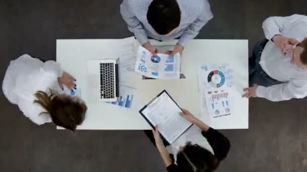 Trabajadores de oficina discutiendo diagramas de negocios y despertando en computadoras portátiles — Vídeos de Stock