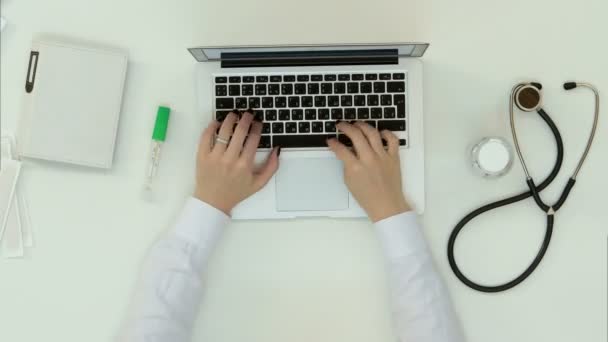 Женские руки врача, печатающие на клавиатуре ноутбука — стоковое видео