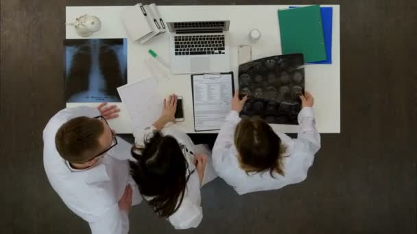 Медична команда обговорює діагностику рентгенівських знімків за допомогою спеціального планшета — стокове відео