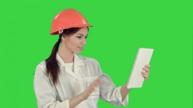 Video aramasý tablet ile bir yeşil ekranda Chroma Key sahip hardhat kadın inşaat uzmanı