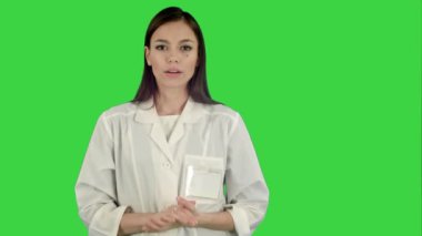 Laboratuar önlüğünü Chroma anahtar yeşil ekran kameraya konuşurken ciddi kadında