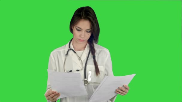 Doctora joven leyendo formularios de historia clínica de pacientes en una pantalla verde, Chroma Key — Vídeo de stock