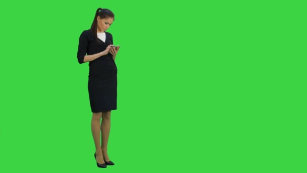 Secretaria concentrada que envía mensajes de texto telefónicos en una pantalla verde, Chroma Key — Vídeo de stock